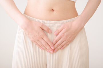 お腹に手を当てる女性